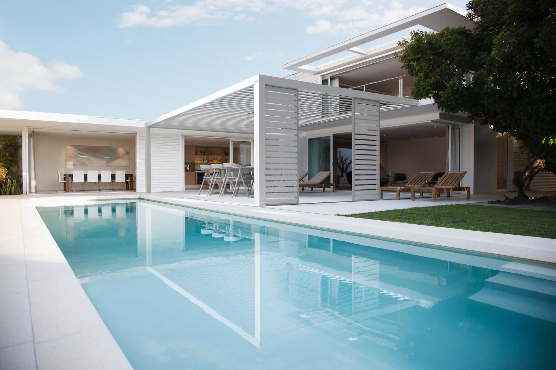 Biela hliníková pergola Soltec pri modernom dome s bazénom
