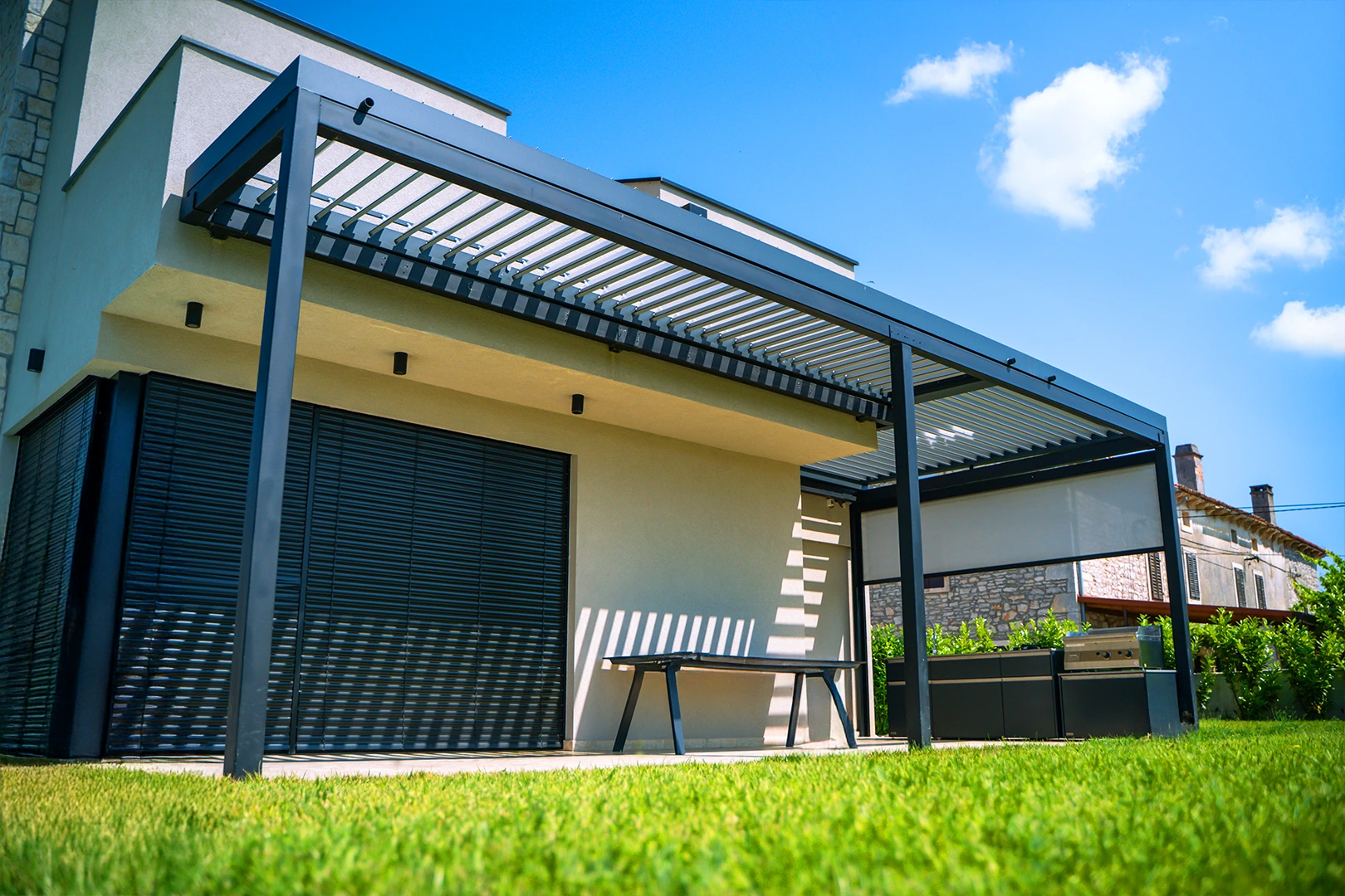 Bioklimatická pergola Soltec pri dome s otvorenými lamelami